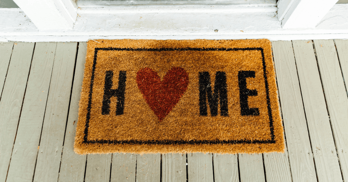 rug at the front door that reads home with a heart