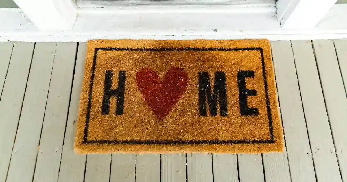 rug at the front door that reads home with a heart