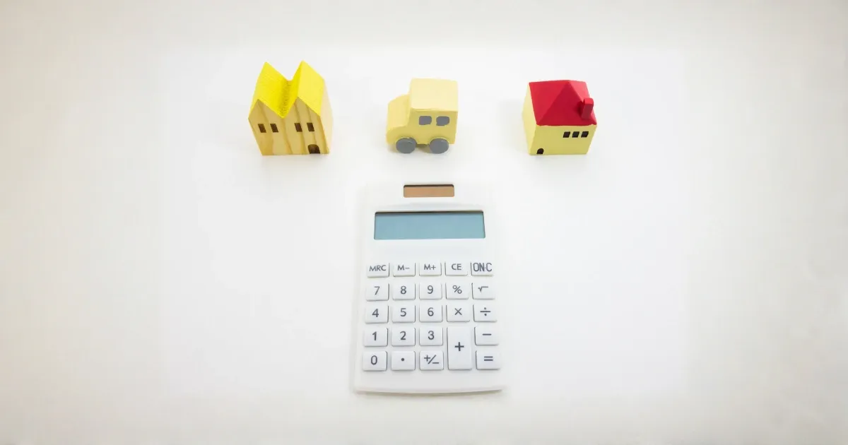 calculator with models of two houses and a van