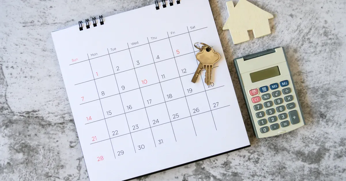 calendar with keys, a calculator and a model of a house
