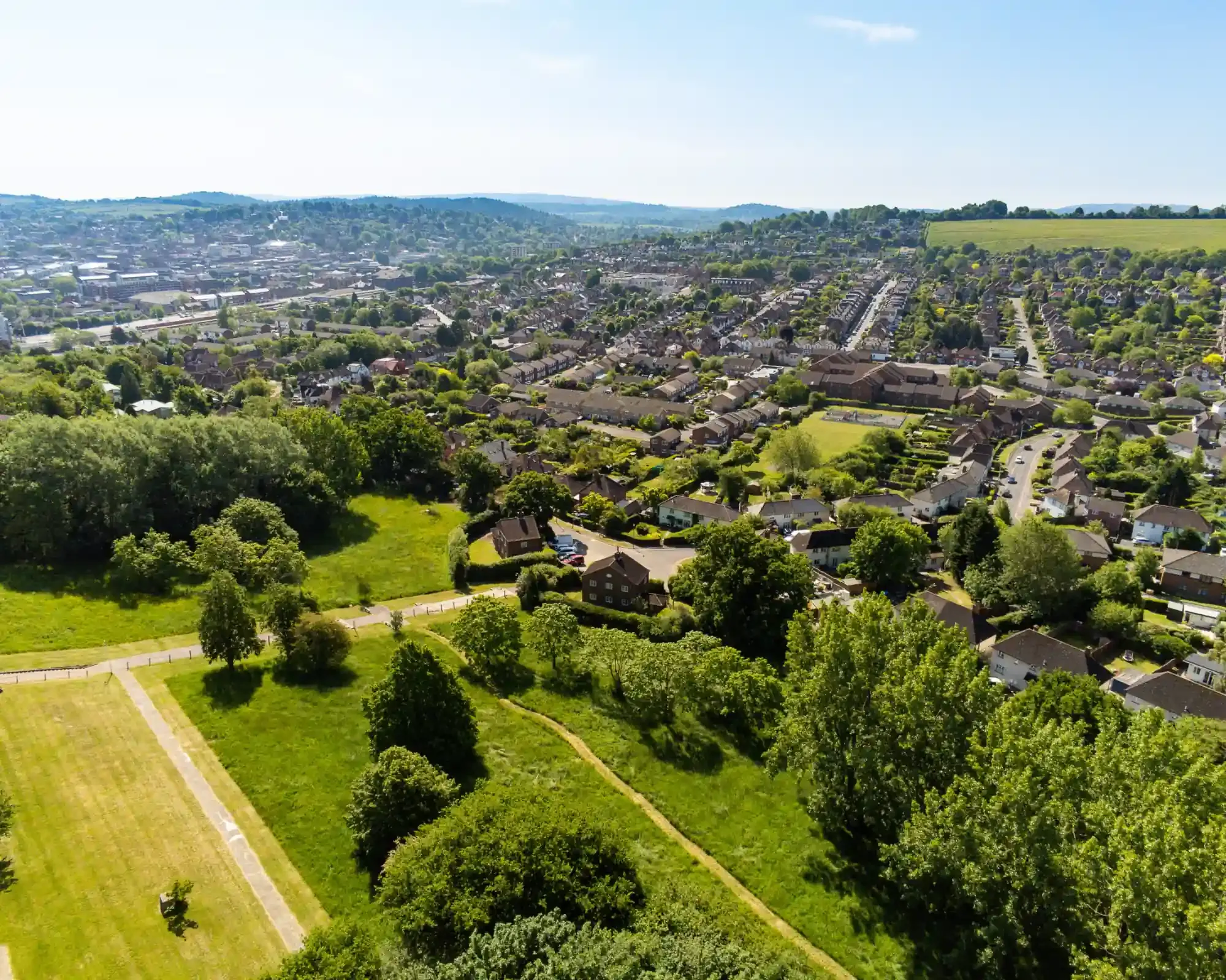 Aerial view of Onslow Village in Guildford, looking across tree-lined streets towards the town centre and the Surrey Hills.