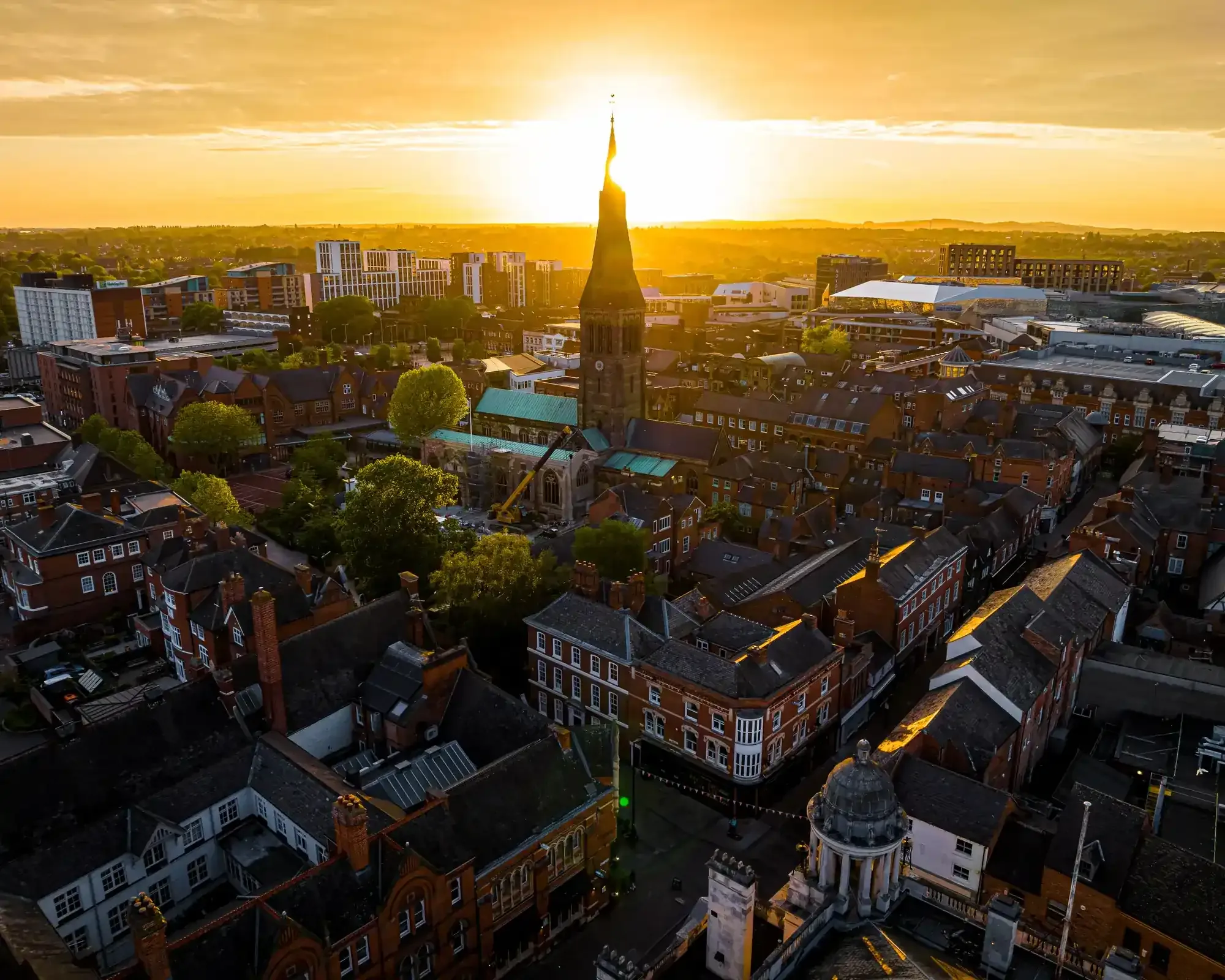 Aerial view of Leicester city centre at sunset, featuring the cathedral spire