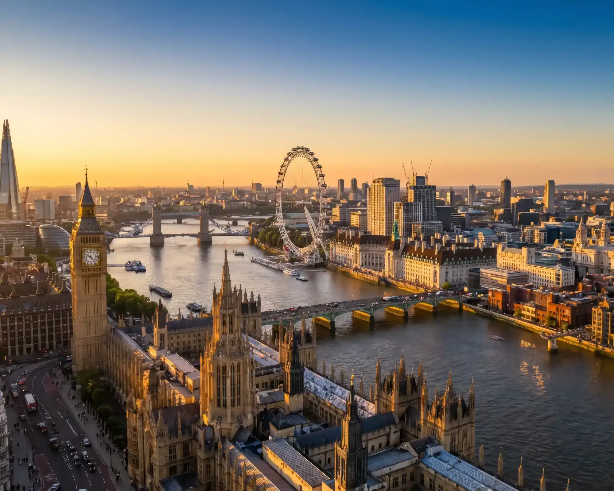 Aerial view of London at sunset, featuring Big Ben, the London Eye and Tower Bridge along the River Thames