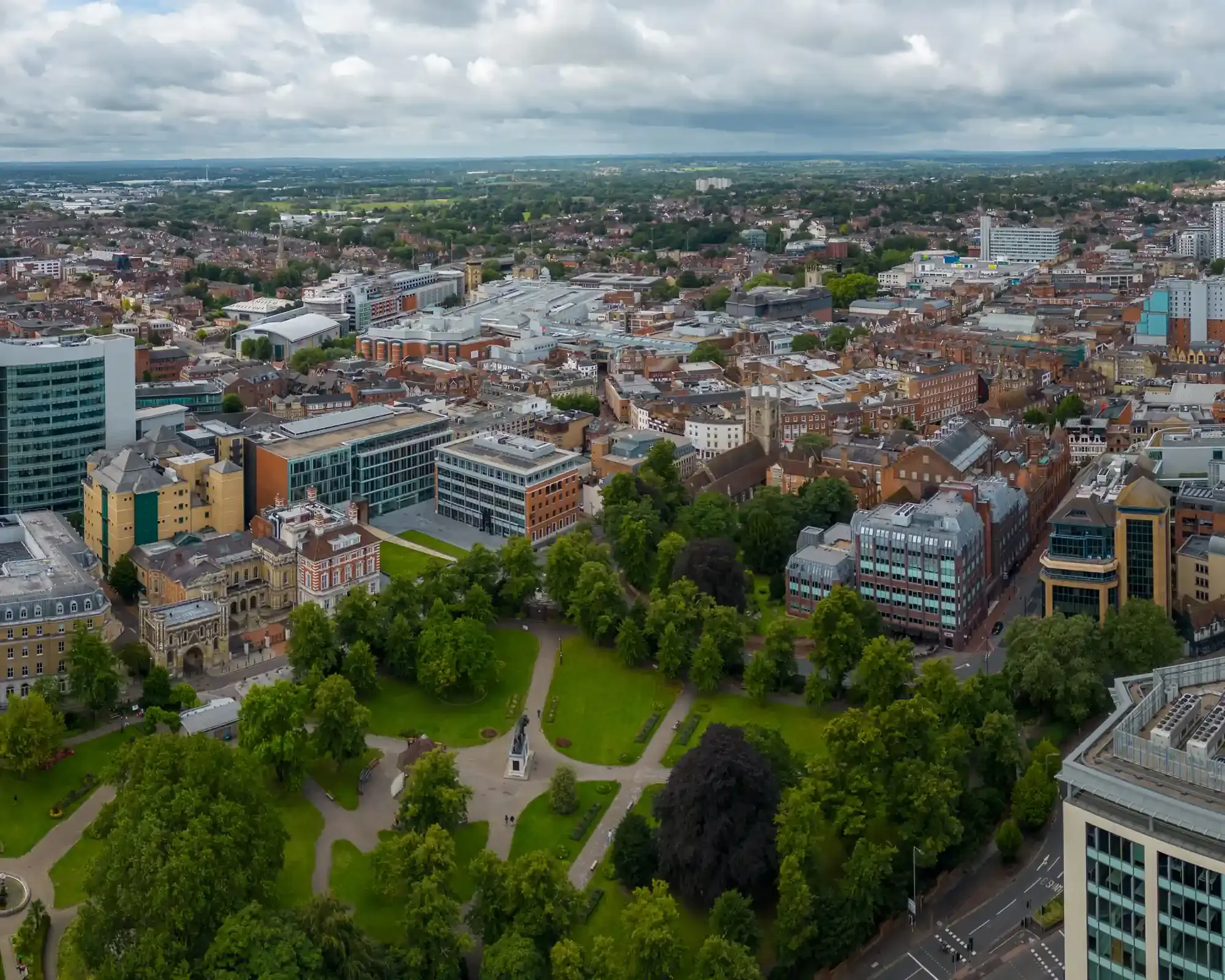 Aerial view of Reading town centre over Forbury Gardens, with the Maiwand Lion statue, the Abbey Gateway and the Oracle shopping area beyond.