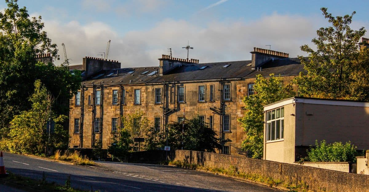Charming historic buildings with lush greenery in Glasgow, Scotland on a sunny day.