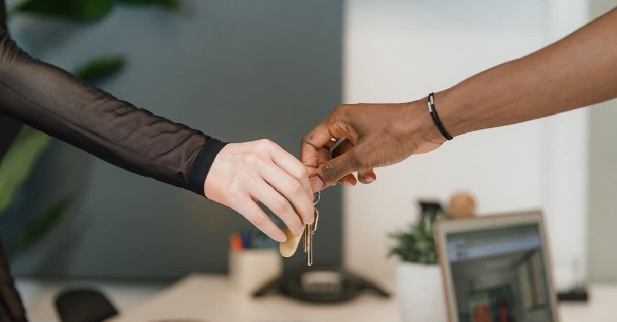 Professional office setting showing a key exchange symbolizing a business deal or real estate transaction.