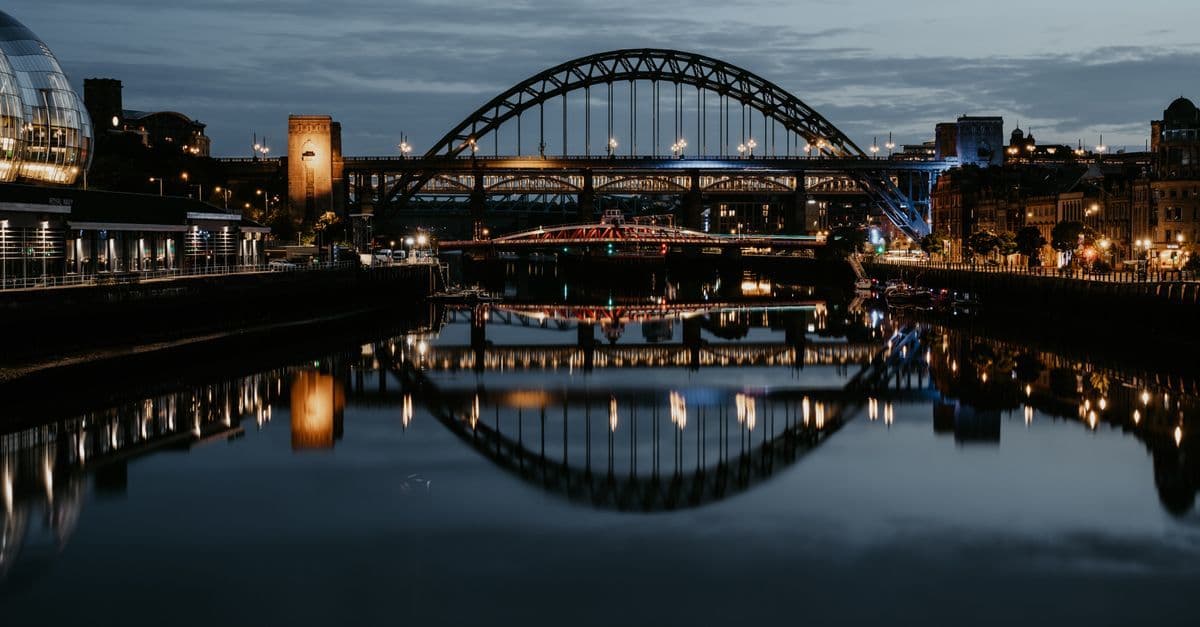 Stunning night cityscape of Newcastle's Tyne Bridge reflecting in the river.