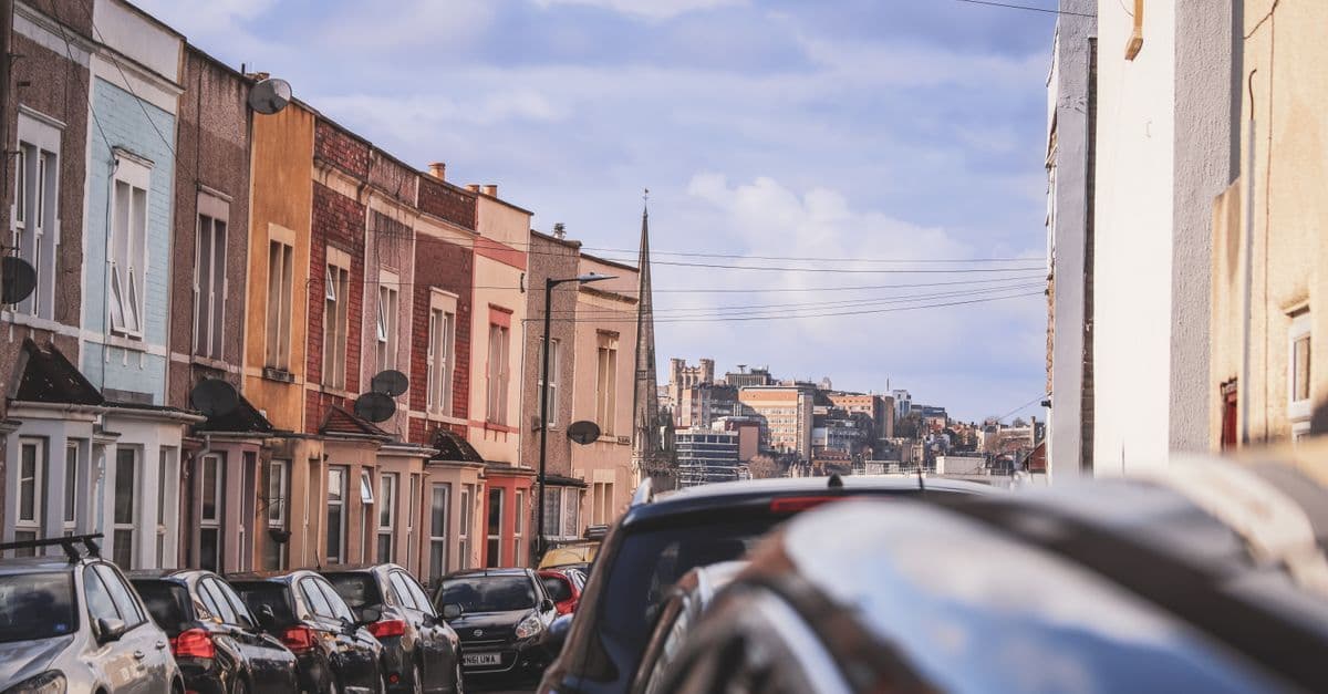 Charming street view in Bristol, England, showcasing colorful townhouses and parked cars.