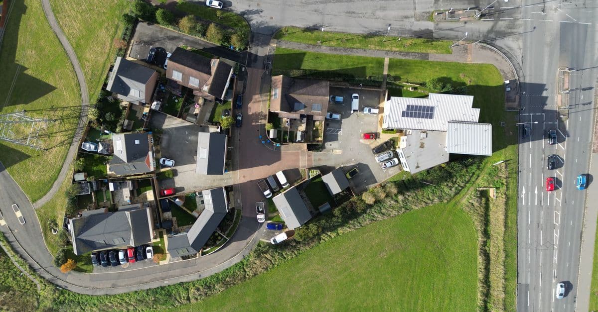 Aerial view of a residential neighborhood in Aylesbury, England, showcasing houses, roads, and parked cars.