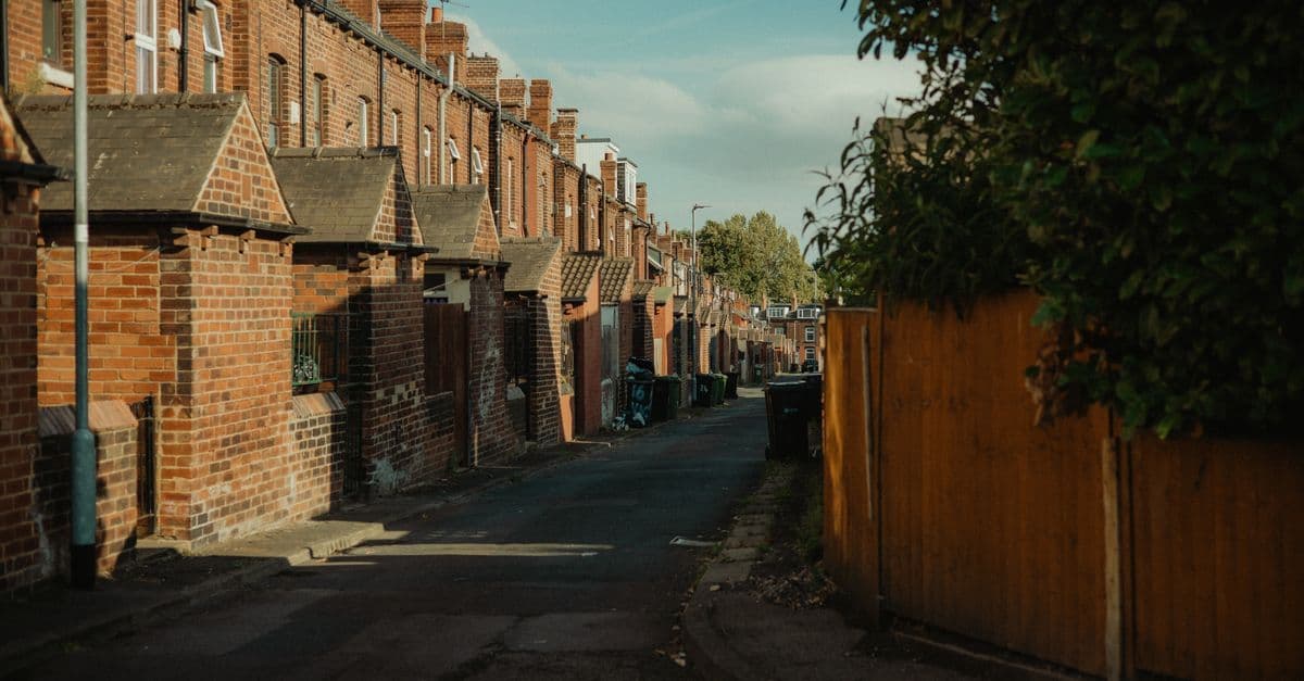 Quaint street view of historic brick row houses in Leeds, England, during a sunny day.