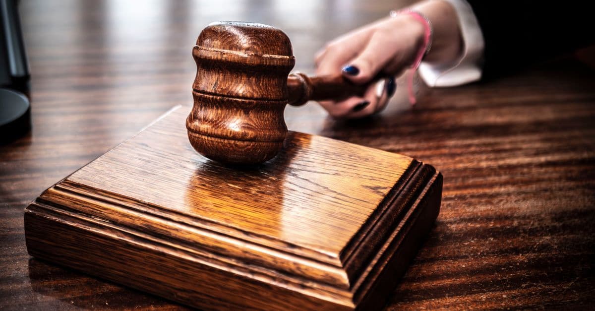 Close-up of a wooden gavel on a judge's desk, symbolizing justice.