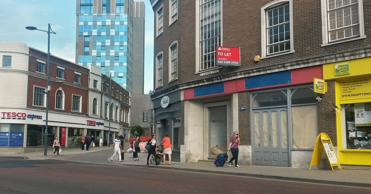 Urban street view in Norwich showcasing diverse architecture and pedestrians.