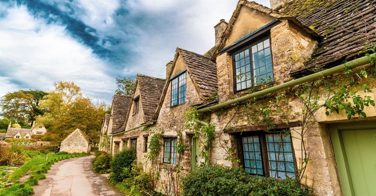 Charming old cottages line a picturesque street in Bibury, England.