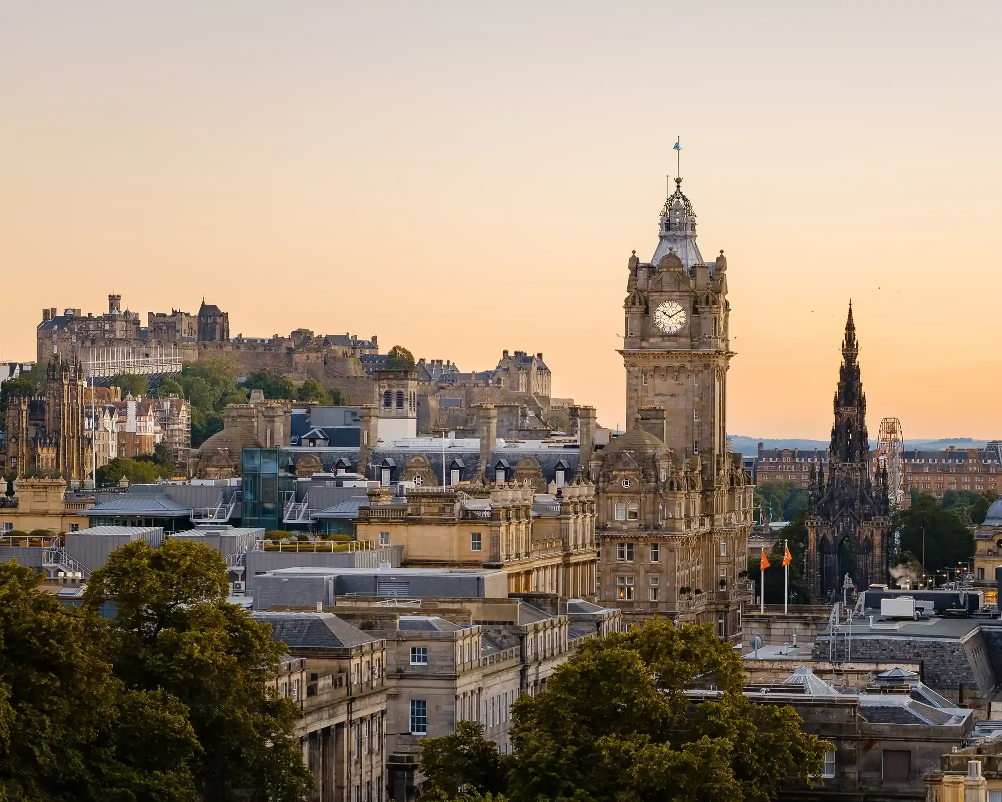 The Edinburgh skyline at sunset from Calton Hill, with Edinburgh Castle, the Balmoral clock tower and the Scott Monument. The whole castle and the Scott Monument are in the frame.
