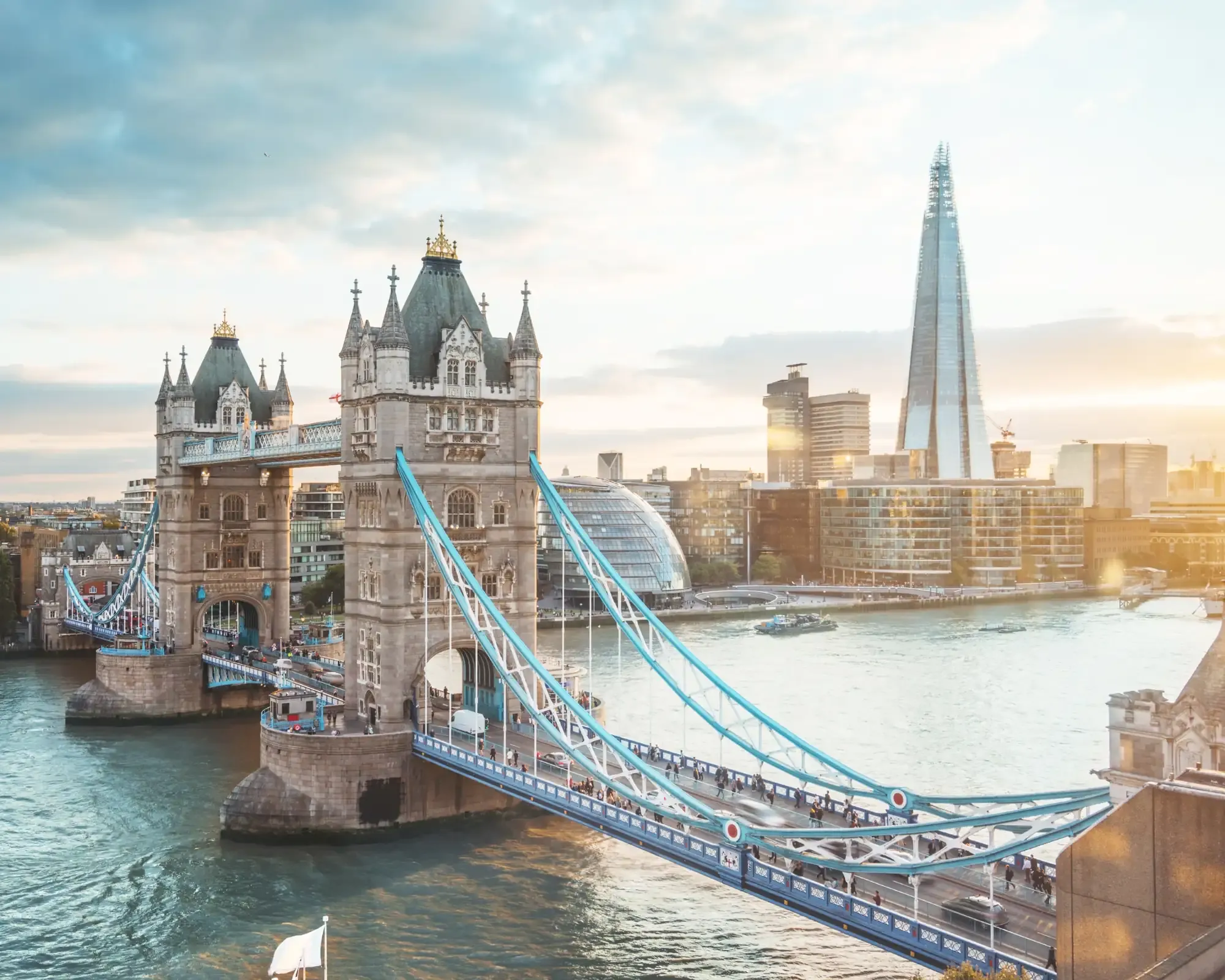 Tower Bridge over the River Thames at sunset, with the Shard and City Hall on the skyline behind.