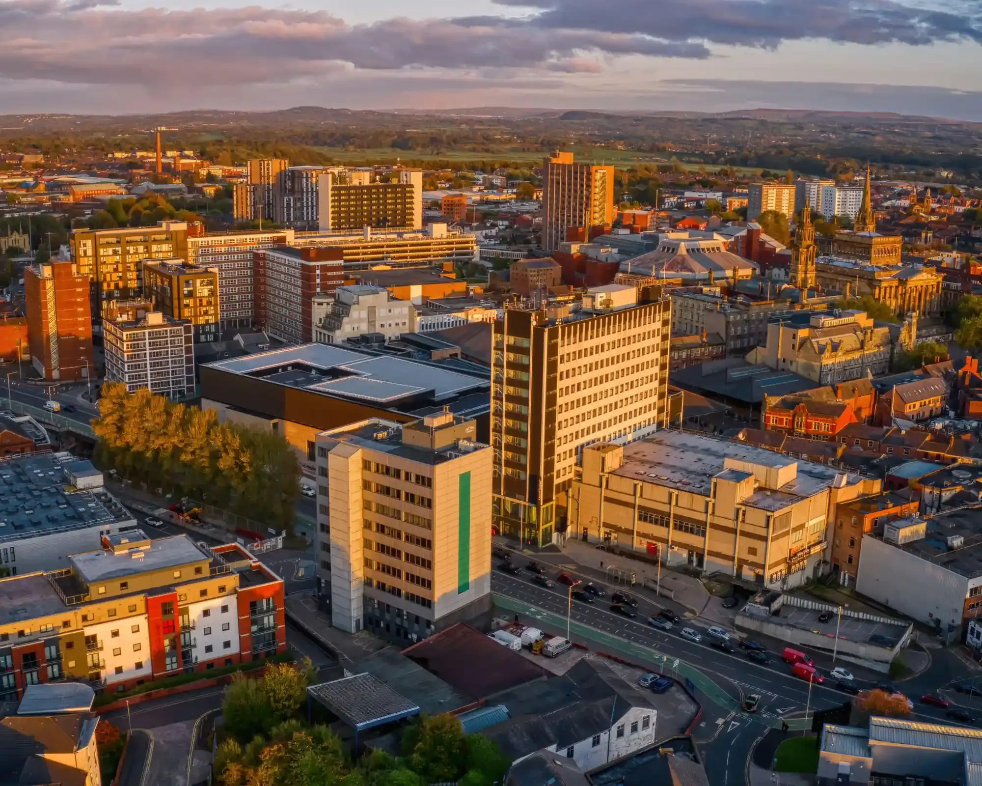 Aerial view of Preston city centre at sunset, with the Harris Museum and the Lancashire hills beyond.
